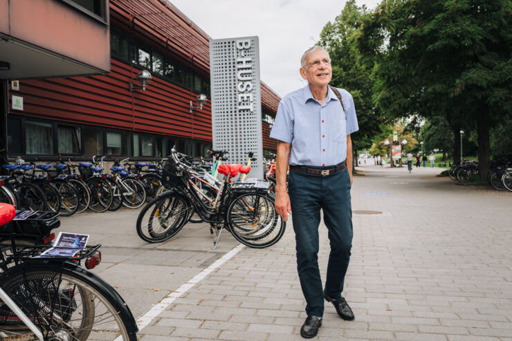 Man utomhus, skylt B-huset i bakgrunden