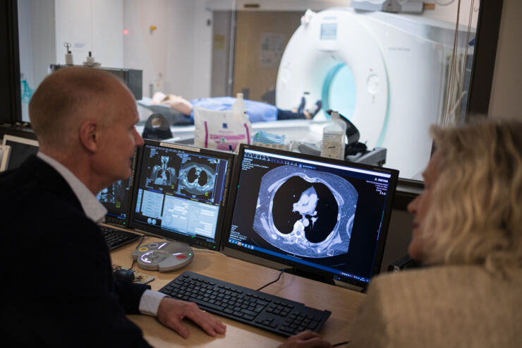 male and female researchers discuss a CT scan.