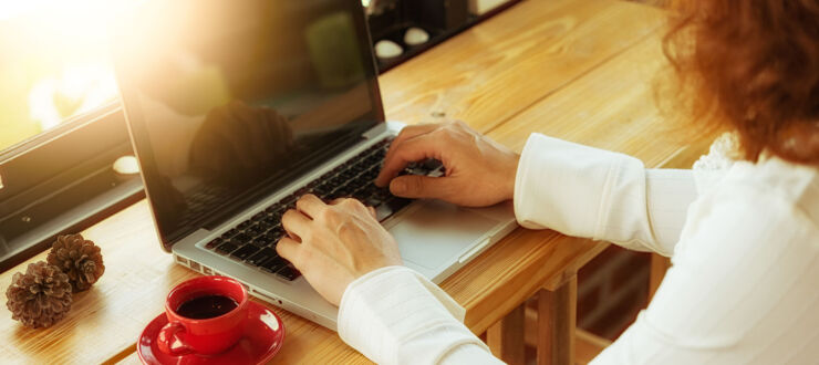 Woman sitting at laptop and writing.