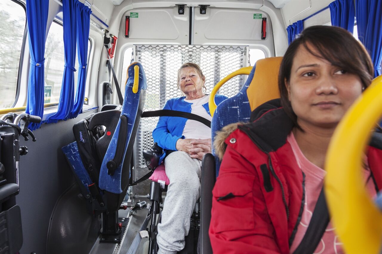 An elderly woman travelling by public transport.