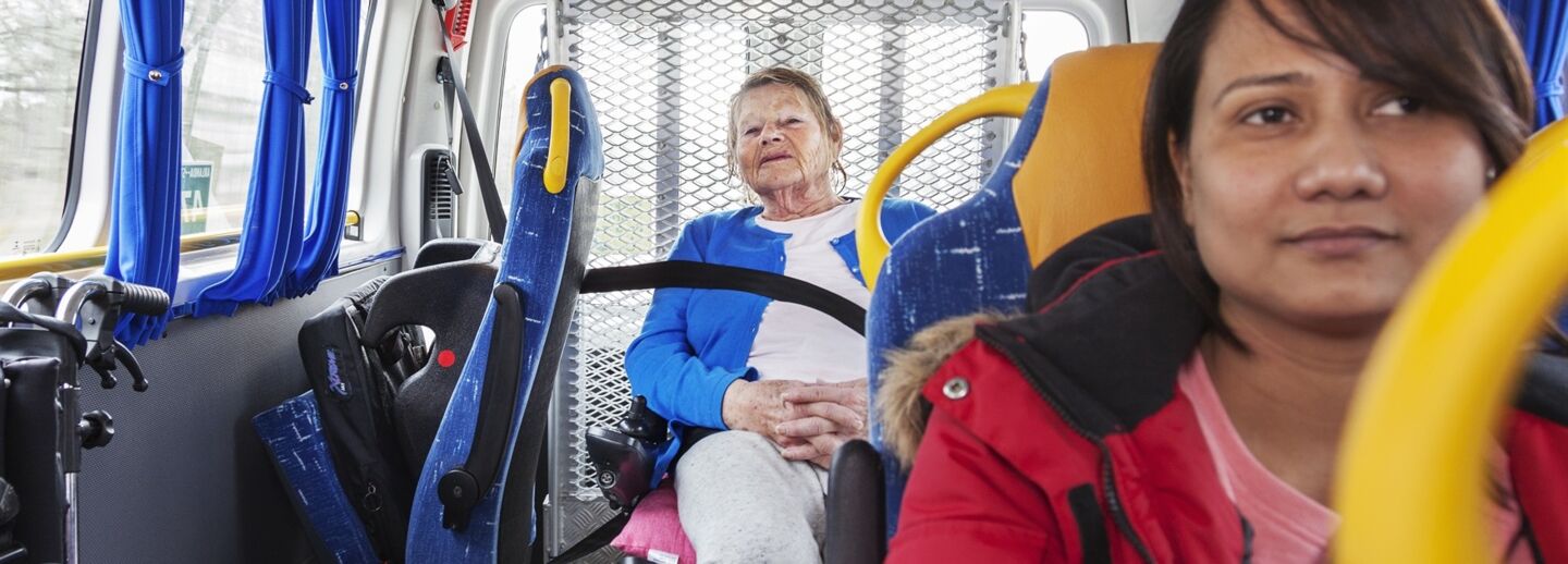 An elderly woman travelling by public transport.