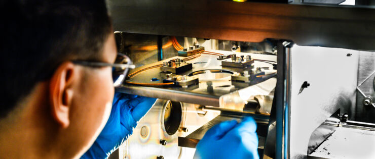 Manlig forskare kontrollerar 3D-printer i laboratoriet.