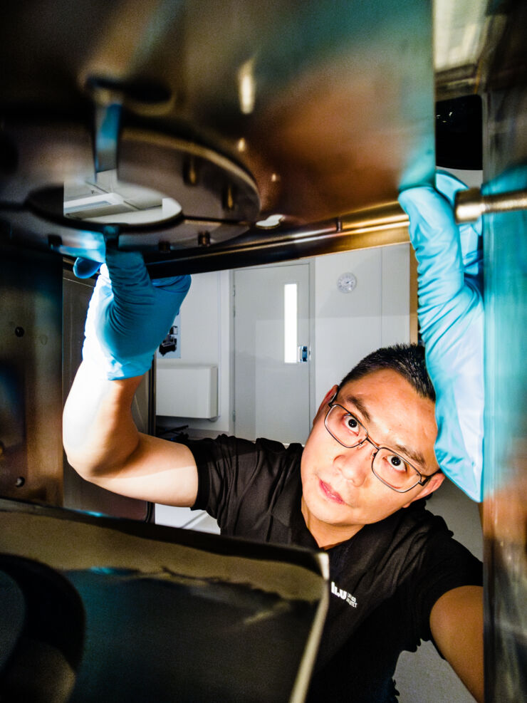 Male scientist checking 3D printer in laboratory.