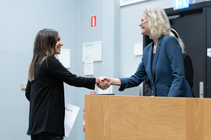 Sara Puente Marin skakar hand med Lena Jonasson och får sitt diplom och blommor.