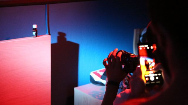 En videokamera och mobil filmar i ett mörkt rum