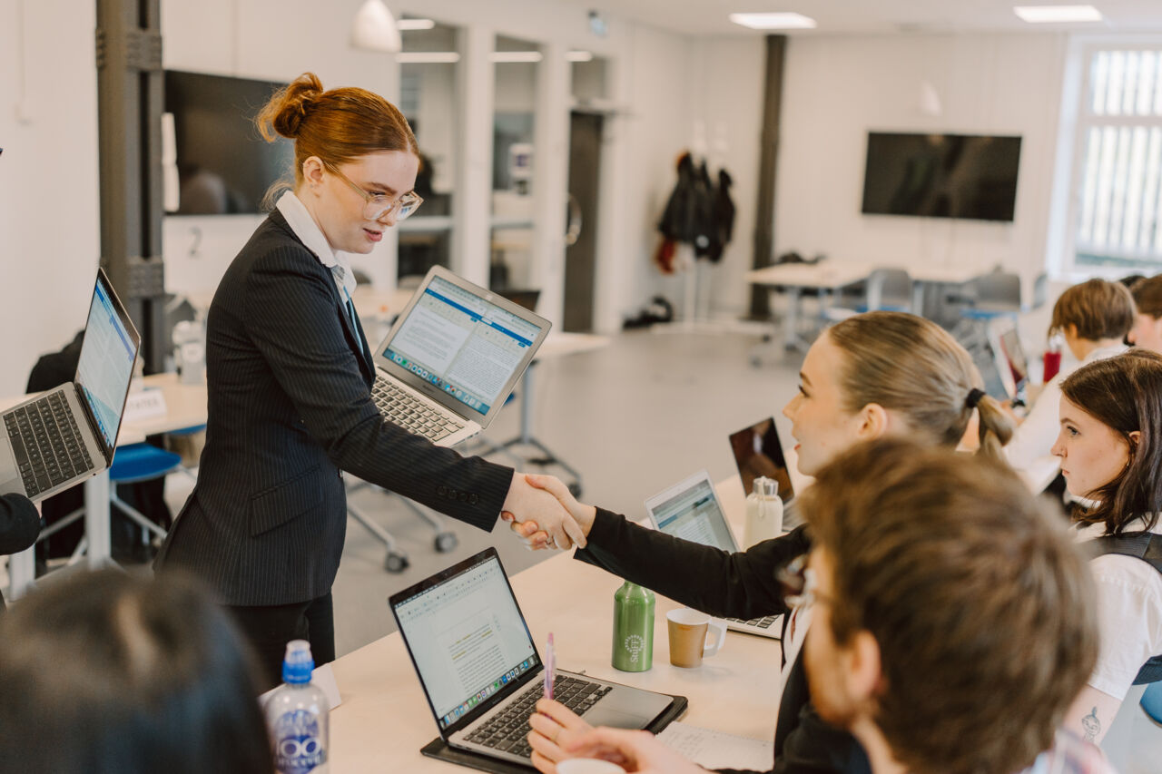 Två studenter skakar hand under ett FN-rollspel