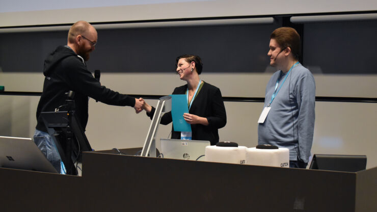 Andreas Larsson, föreståndare för NATDID, delar ut pris till Linn Hedenskog och Fredrik Hedenberg.