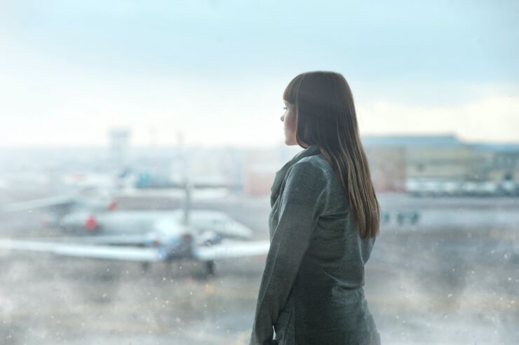 Kvinna blickar ut över flygplats.