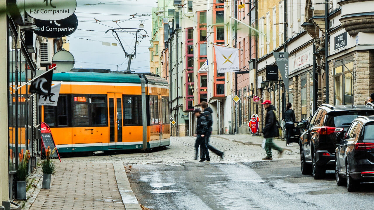 Spårvagn och människor i stadsmiljö.