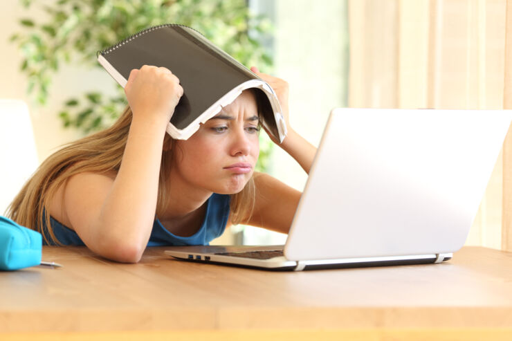 Frustrerad flicka framför dator.