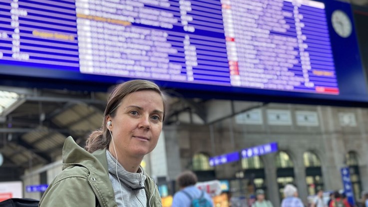 Kvinna på tågstation i Europa. 