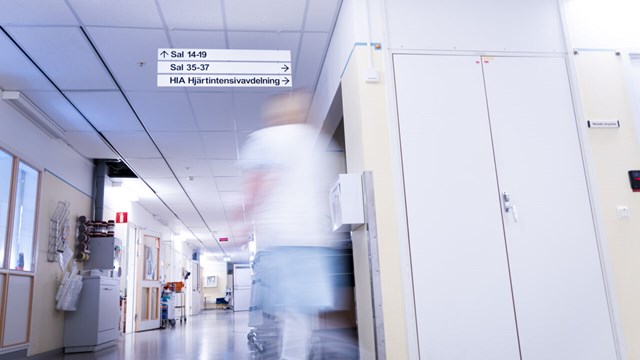 Sjuksköterska går i sjukhuskorridor.