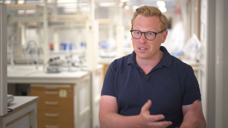 Man wearing glasses and blue polo shirt in laboratory