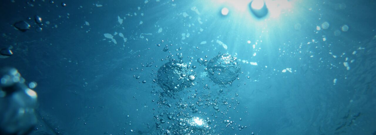 Luftbubblor i blått vatten