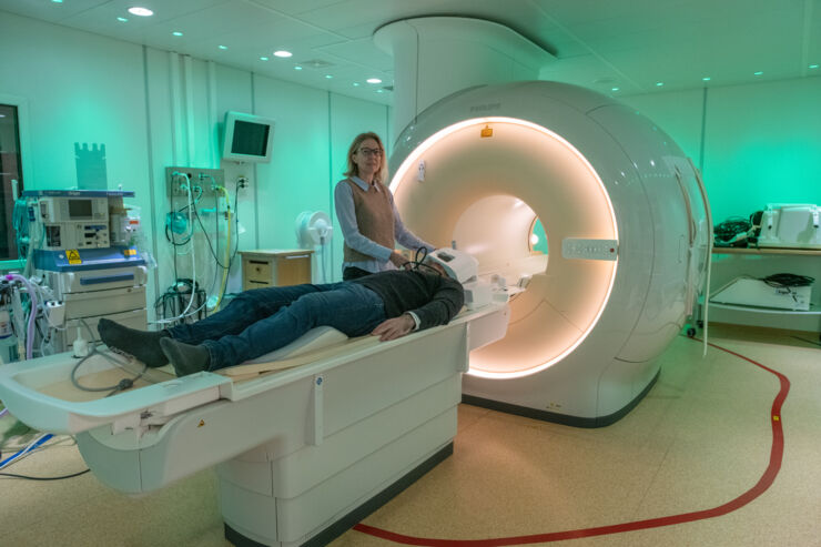 A woman preparing a person for examination with magnetic resonance tomography.