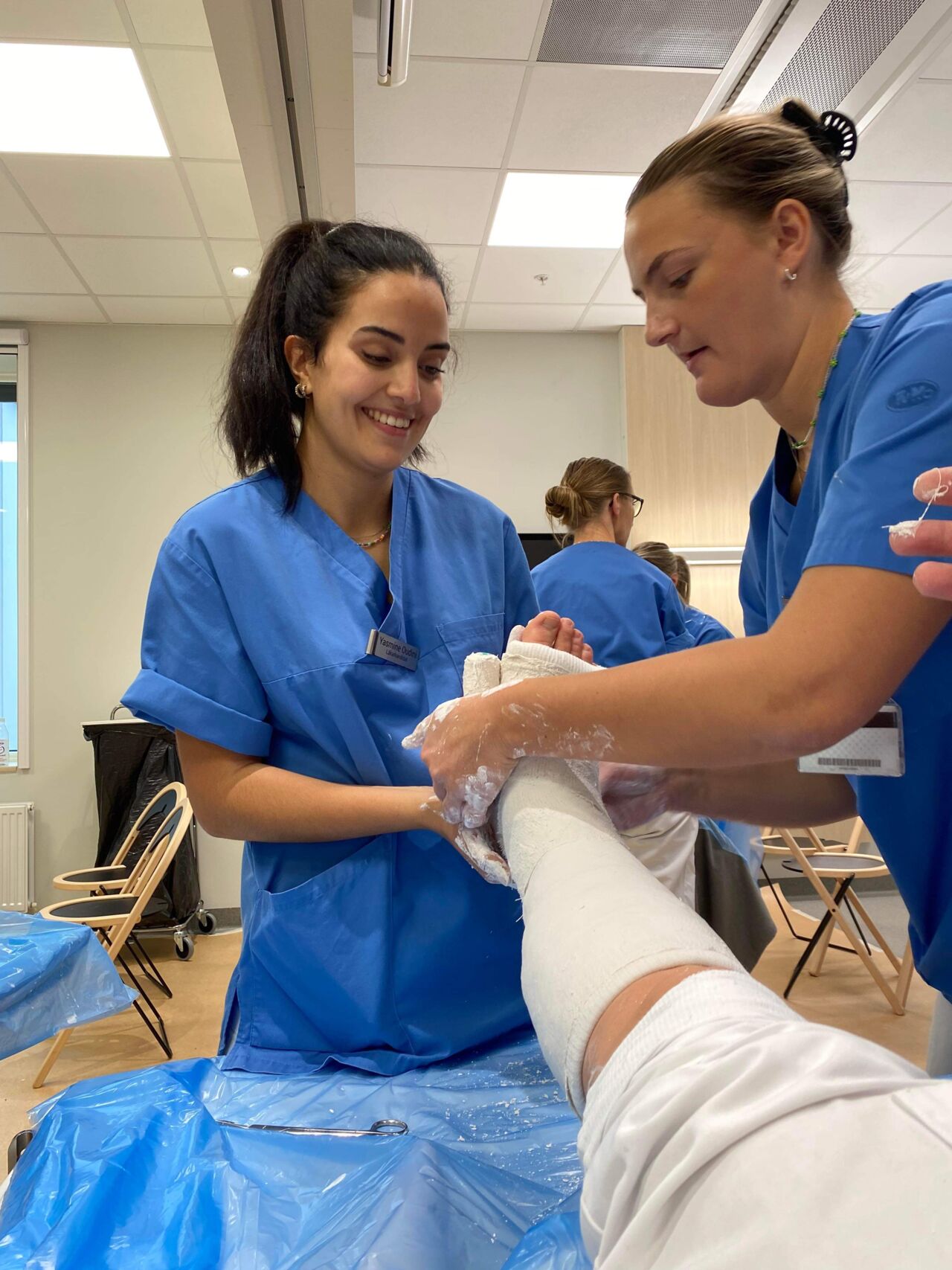 Två studenter tränar på att gipsa ett ben.