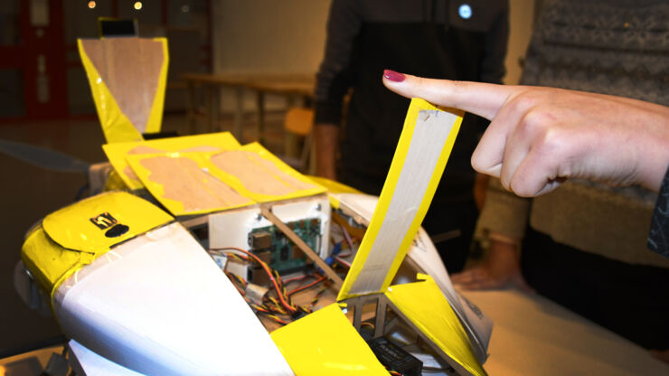 A red nailed finger pointing at the electronics in the aircraft.