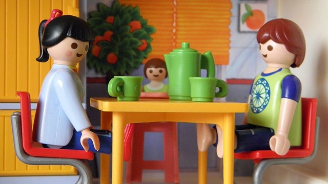 Leksaksfamilj i playmobile sitter vid middagsbord