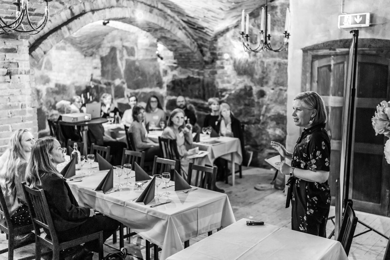 Lisa Guntram presenterar i ett rum fullt av sittande publik