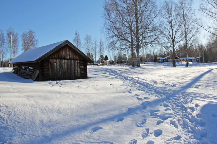 bild på ett snötäckt landskap och en brun stuga