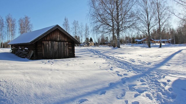 bild på ett snötäckt landskap och en brun stuga