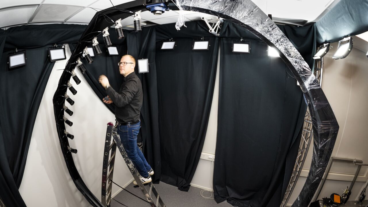 En man på en trappstege bredvid en cirkulär rigg.