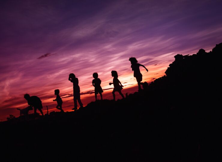 Silhouettes of several children in the sunset