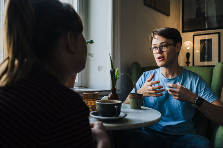 Två personer sitter och pratar.