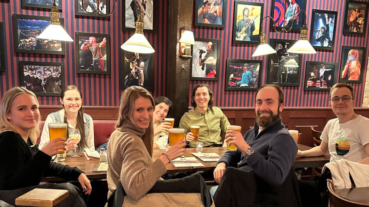 Group sitting in a restaurant each with a drink in their hands.