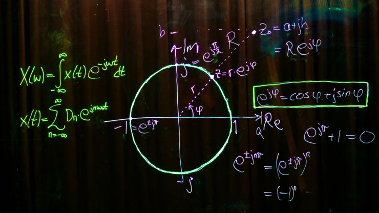 Matematiska formler skrivna med olika färger mot svart bakgrund