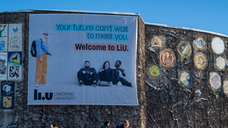 Winter day. A Canvas on building wall with text that welcomes you to LiU.