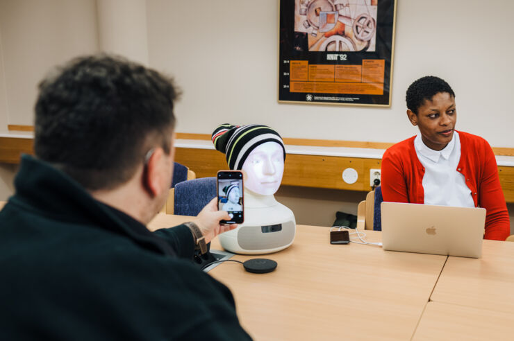 Researchers interact with a reading robot.