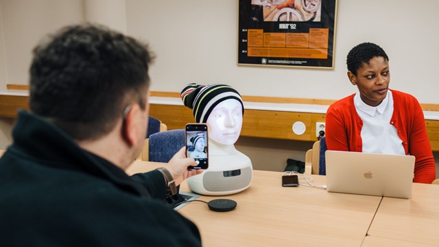 Researchers interact with a reading robot.