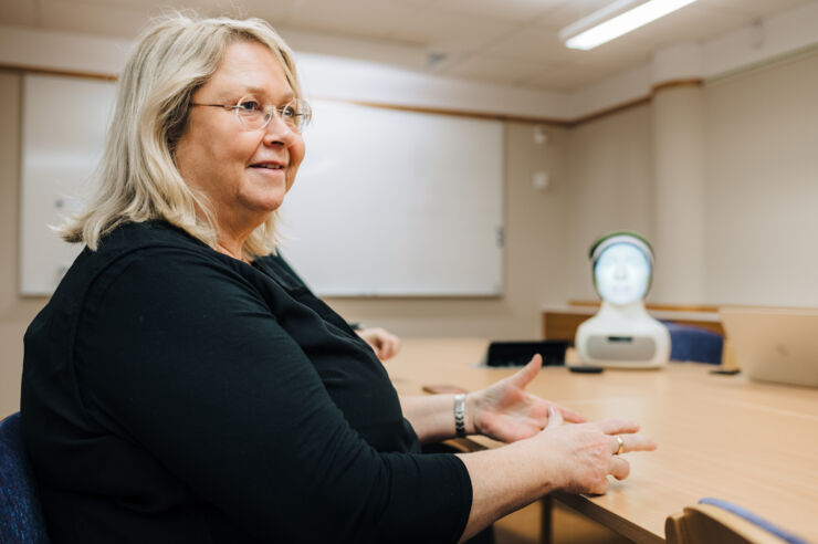 Female researcher and a reading robot.