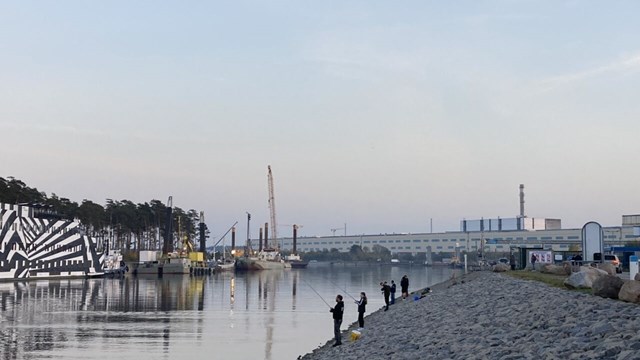 Personer fiskar bredvid ett kraftverk