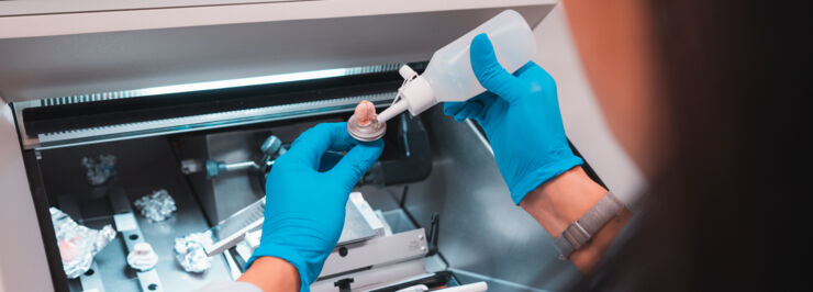 Researchers wearing blue gloves are working in a lab.