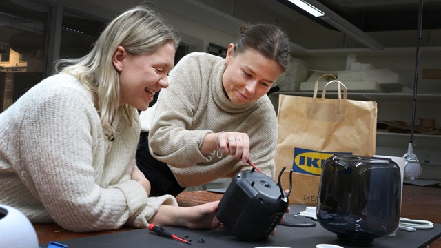 Two female student, dissasembling an Ikea product.