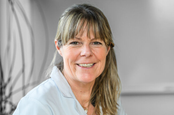 Headshot of woman wearing lab coat.