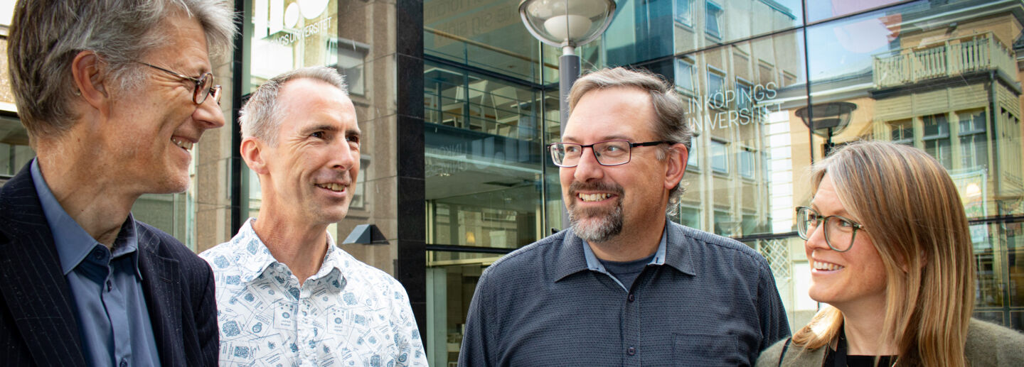 Three men and a woman outside Campus US. 