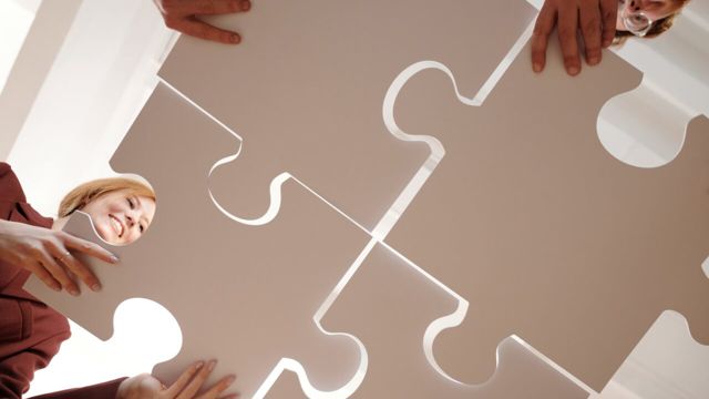 A group of people holding in a jigsaw