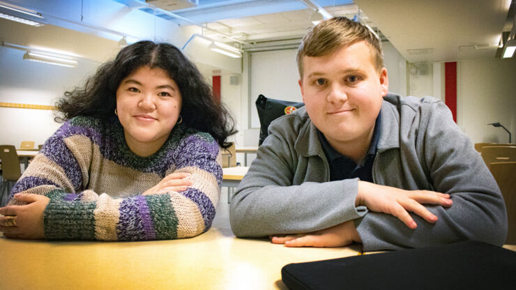 Female and male student sitting in classrom.