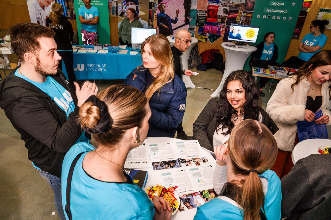 Studenter minglar runt ett bord