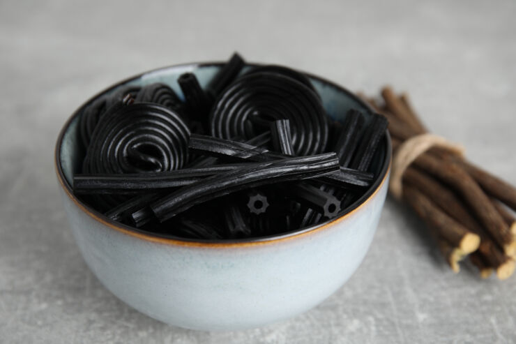 Liqourice in a bowl with liquorice roots next to it.