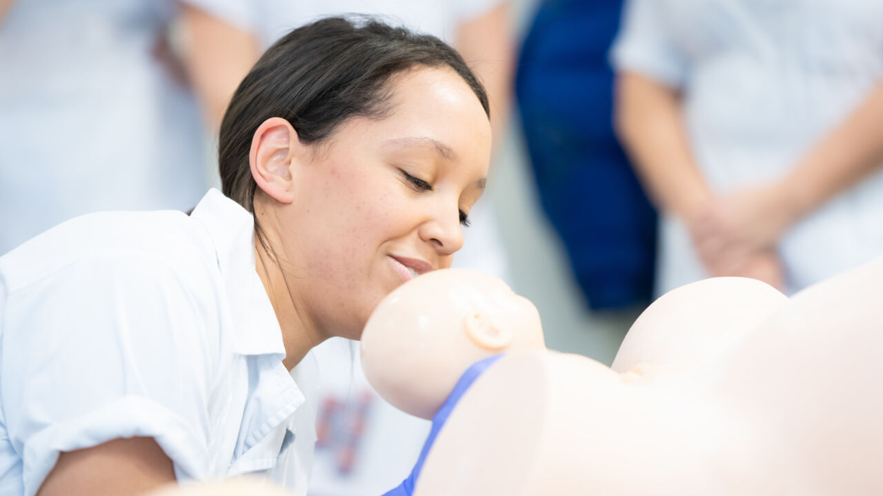 Barnmorskestudent övar handgrepp vid barnafödsel.