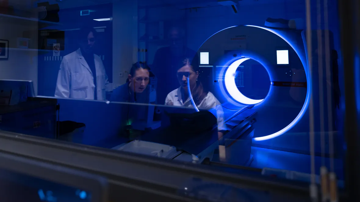 Four researchers in the control room of a photon-counting CT scanner.