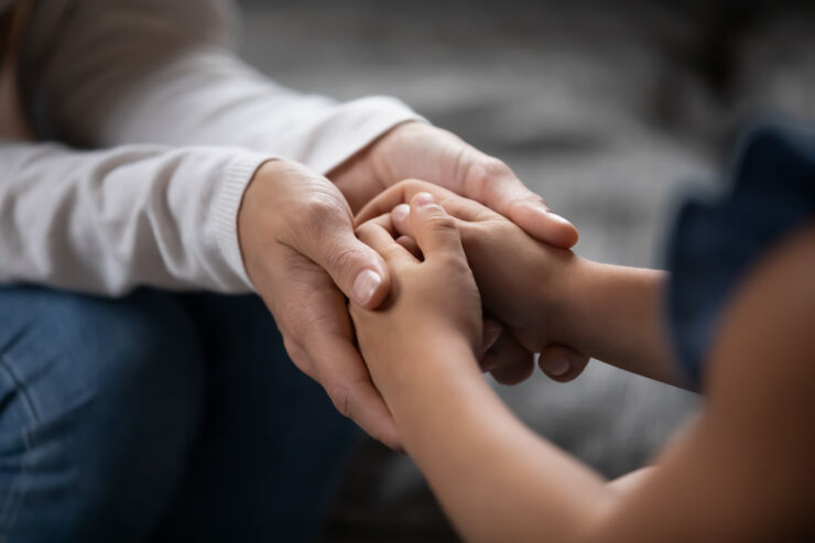 Två personer sitter och håller händer.