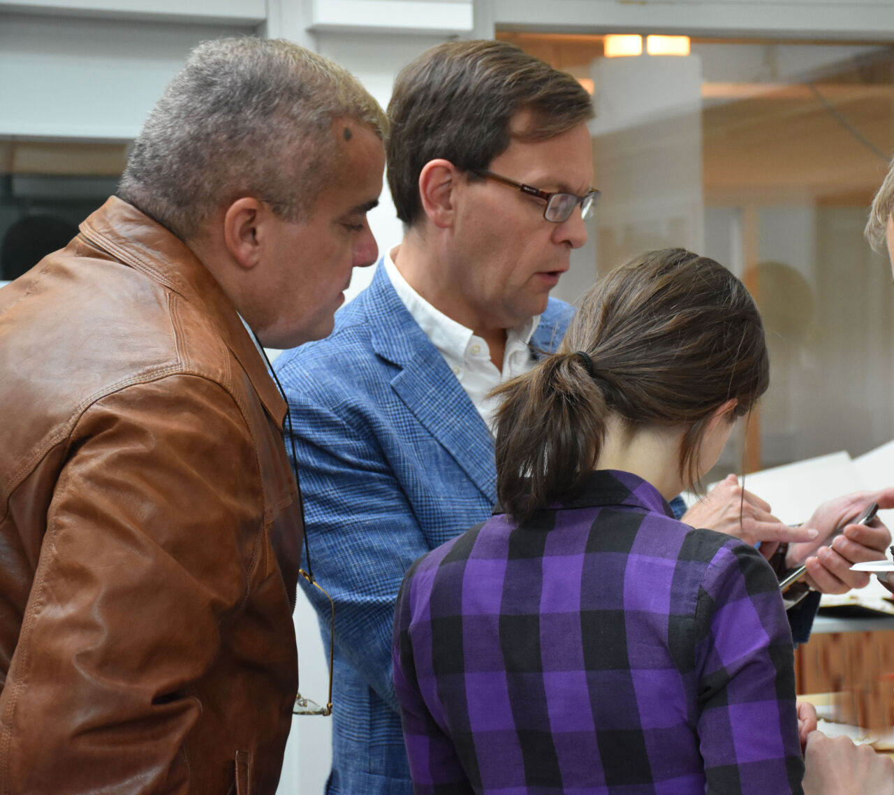 Tre personer tittar på ett dokument.