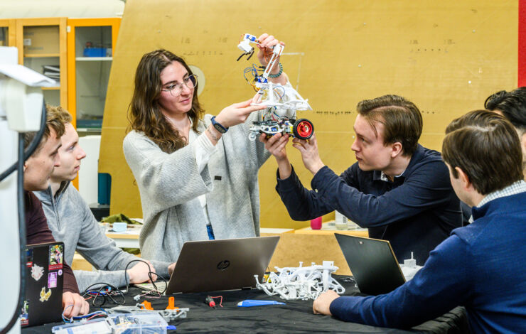 Female PhD student lectures to master's students in the lab.