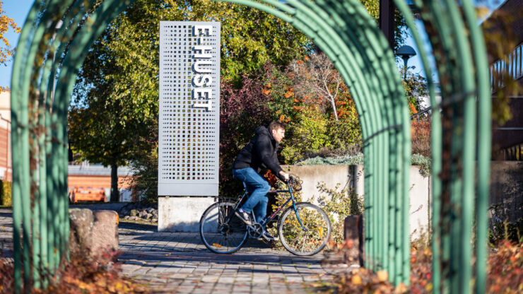 Höstbild med skylt E-huset och cyklist