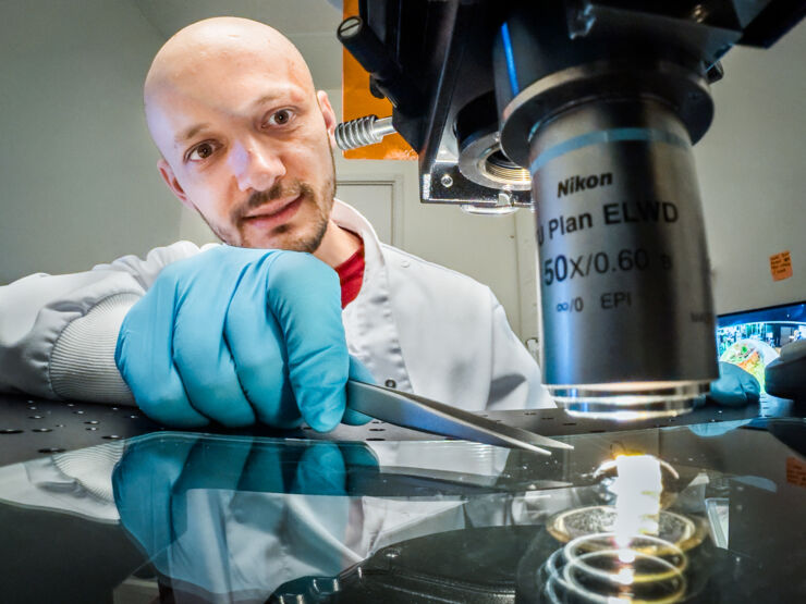 Researcher (Xenofon Strakosas) by a microscope.